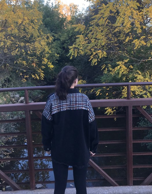 back shot of woven jean jacket girl wear it, on bridge.